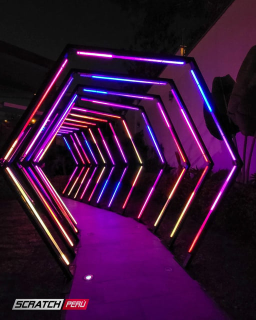 Túnel LED hexagonal RGB: Destacando el acceso a una casa de eventos con luces cambiantes de múltiples colores.