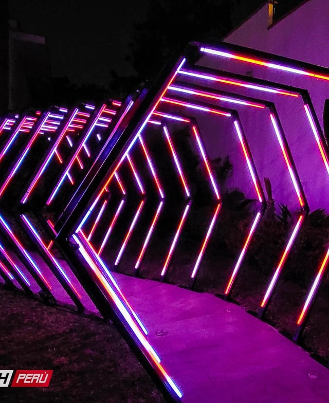 Túnel LED hexagonal multicolor: Efectos luminosos espectaculares en el camino hacia un evento, con luces cambiantes y vibrantes.