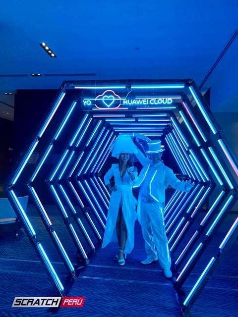Túnel LED hexagonal cian: Recepción elegante con iluminación cian, destacando la bienvenida a los invitados.