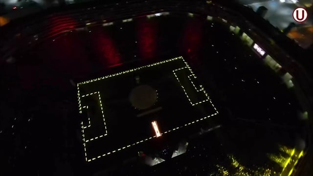 Vista general de un estadio de fútbol con el contorno de la estructura iluminado por píxeles LED y los espectadores usando brazaletes LED que se encienden y apagan según el desarrollo del partido, creando una atmósfera única y emocionante