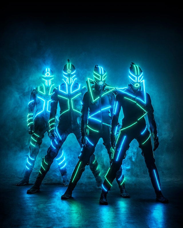Grupo de bailarines Powerman con trajes de neón LED azul
