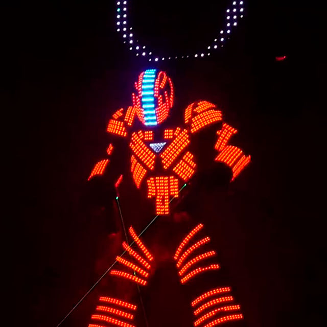 Bailarín Lightman con traje LED naranja y casco iluminado