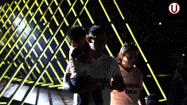 Vista desde el interior de un túnel de píxeles LED por el que salen los jugadores de fútbol al campo, con los nombres y los números de los jugadores proyectados en las paredes del túnel