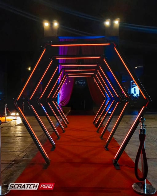 Túnel LED hexagonal rojo: Entrada deslumbrante con iluminación LED para eventos en rojo vibrante.