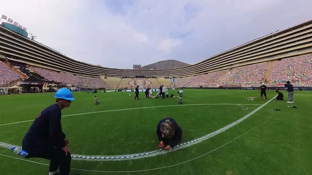 Vista desde las gradas de la cancha de fútbol iluminada en color morado, con los mini píxeles controlados en tiempo real para crear un ambiente festivo y moderno