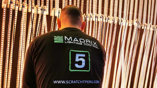 Técnico de Scratch Perú frente a tubos pixel LED controlados con Madrix 5