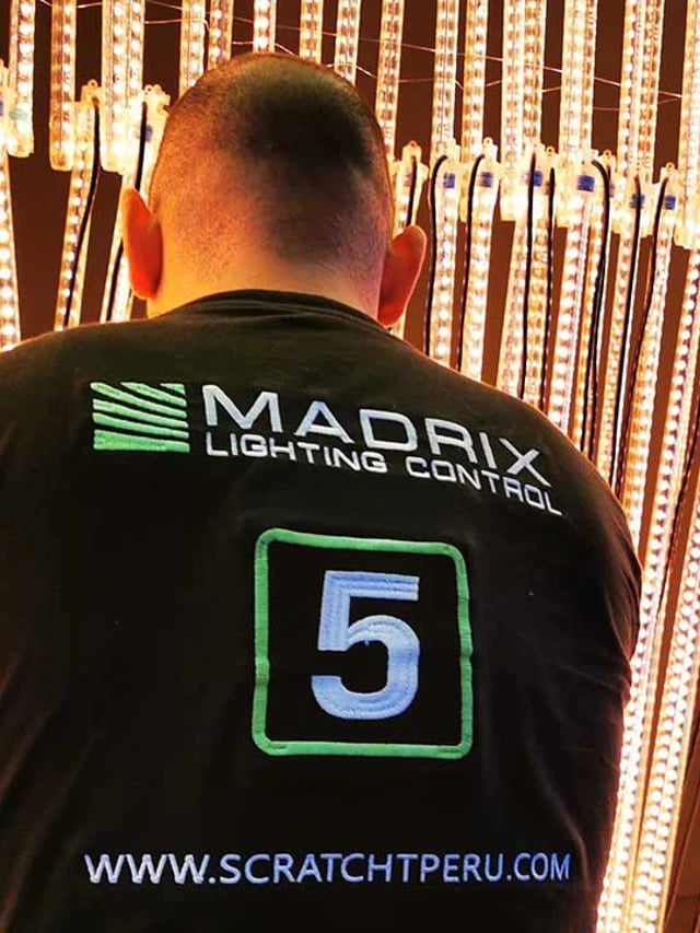 Técnico de Scratch Perú frente a tubos pixel LED controlados con Madrix 5