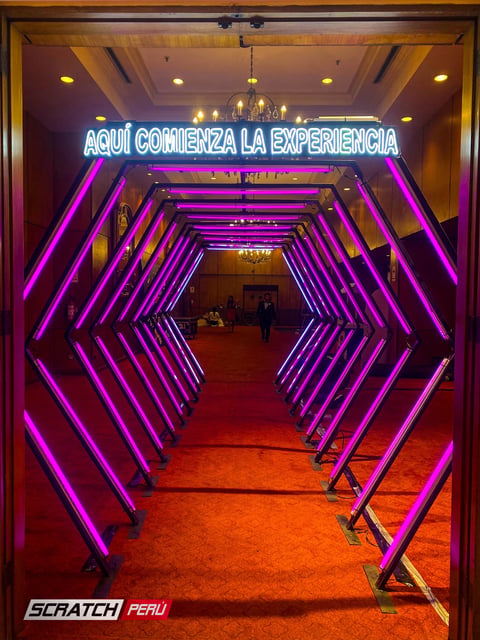 Túnel LED hexagonal violeta: Acceso elegante al área de conversiones en el Hotel Westin, resaltando la exclusividad del evento.