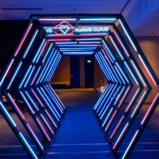 Túnel LED hexagonal azul Huawei: Diseño único con el logo de Huawei, ideal para eventos exclusivos.