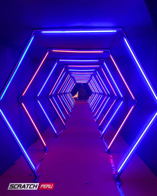 Túnel LED hexagonal rojo y azul: Efectos de luz vibrantes en un pasillo, creando una experiencia visual impresionante.
