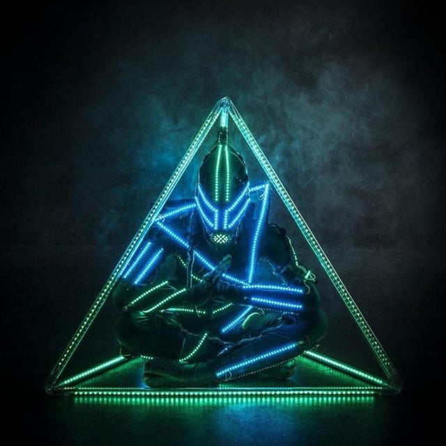 Bailarín Powerman con traje de neón LED dentro de un triángulo verde